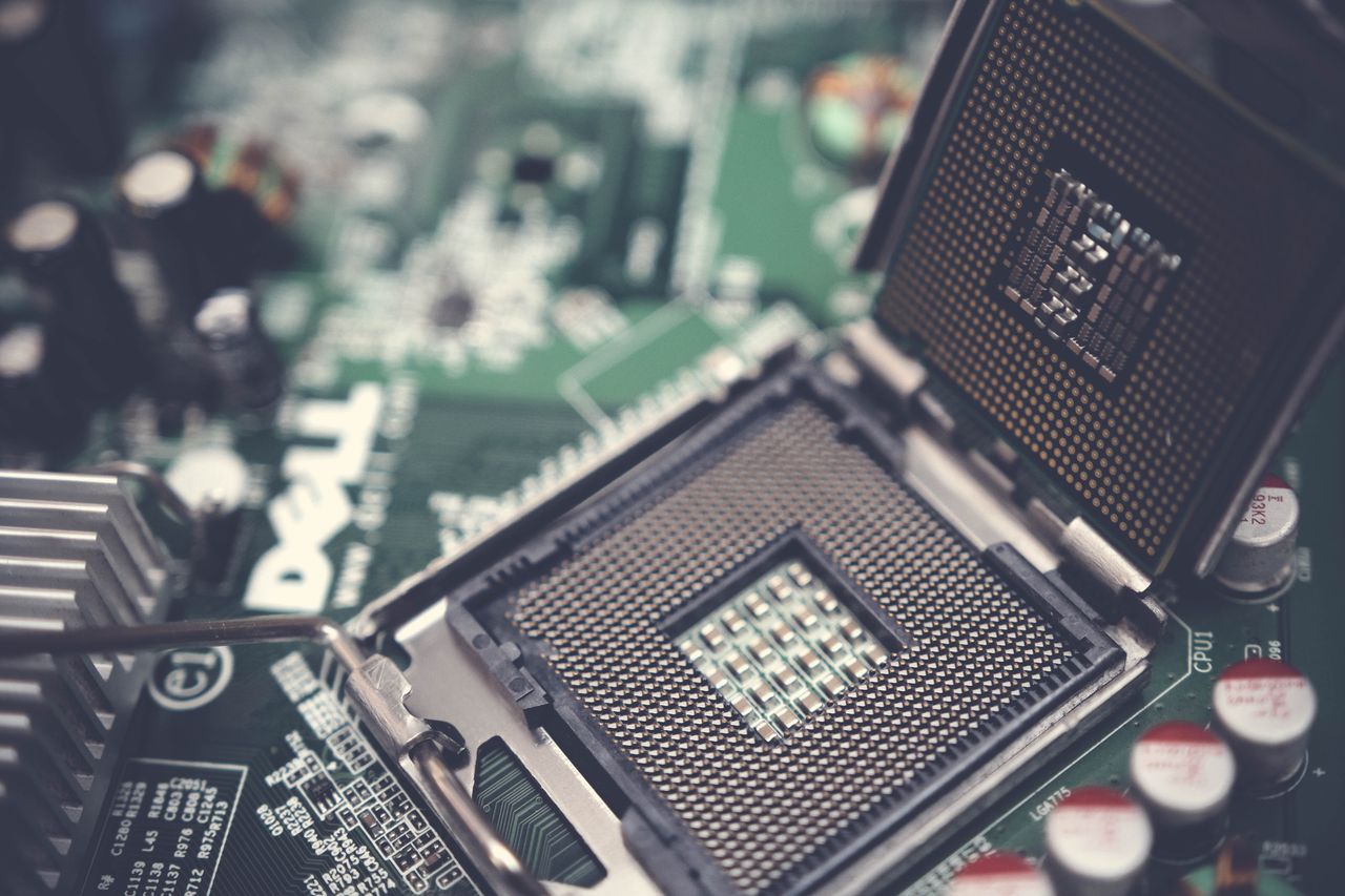 about-us Detailed view of a CPU socket on a green motherboard, showcasing microprocessor technology.