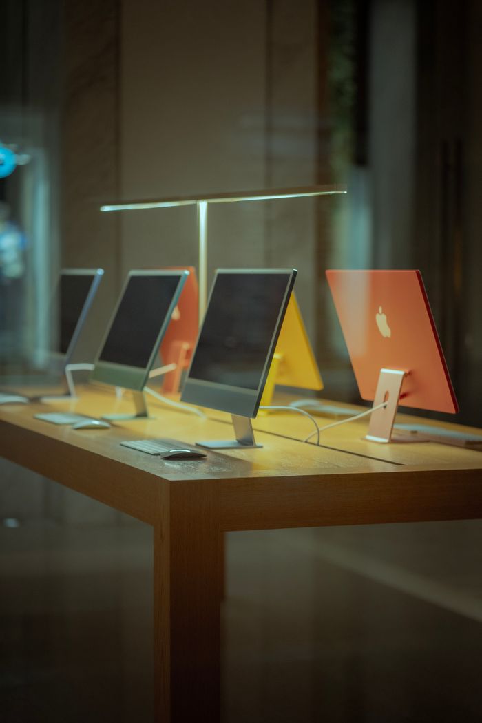 services-01 Vibrant desktop computers showcased on a wooden table in modern retail environment.